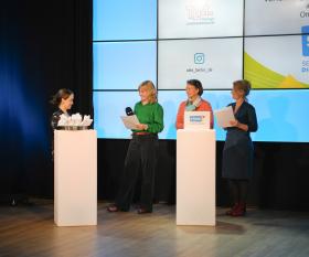 Sabine Kühnel-Schwarz, Internet-ABC e. V., Internet-ABC Frau hinter Pult hört der Verlesung der Laudatio zu