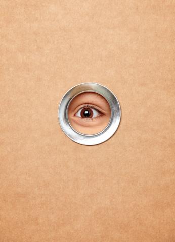 Ein Auge blickt durch ein Guckloch